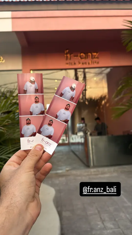 Two fr-anz photobooth strips held up in front of the café